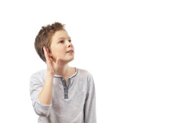 Çocuk elini kulağına dayayıp beyaz arka planda izole edilmiş bir şekilde dinledi..