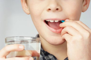 a child putting a pill in his mouth