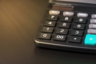 Siyah arkaplanda bir hesap makinesinin yakın plan görüntüsü