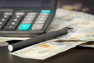 Siyah masa arkasında Amerikan doları olan hesap makinesi, finansal konsept