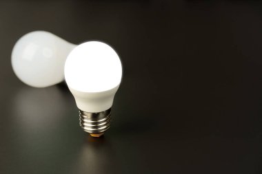 İki enerji tasarruflu LED lamba, siyah arka planda. Düğmeyi kapat.