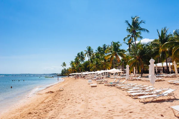 Liegestühle und Sonnenschirm am atemberaubenden tropischen Strand — Stockfoto