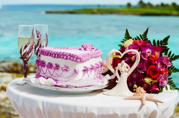 Dekoratives Glas Champagner, Hochzeitstorte und Brautstrauß auf einem Dekorationstisch — Stockfoto