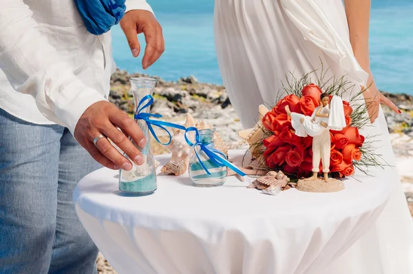 Руки нареченої тримають вазу з барвистим піском під час весілля — стокове фото
