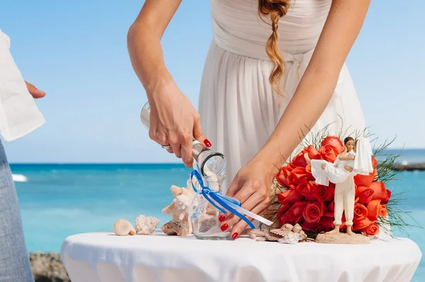 Руки нареченої тримають вазу з барвистим піском під час весілля — стокове фото