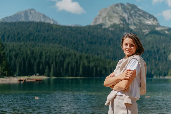 소녀는 몬테네그로 두미 토르 국립 공원의 검은 호수와 숲 과 산을 바라본다. 관광객은 호수의 마법적 인 풍경, 울창 한 숲, 그리고 마법적 인 풍경을 즐기며 — 스톡 사진