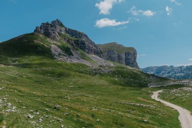 Durmitor dağları, Ulusal Park, Akdeniz, Karadağ, Balkanlar ve Avrupa 'nın muhteşem manzarası. Sedlo Geçidi 'nden parlak yaz manzarası. Dağlardaki evin yanındaki yol..