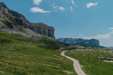 Durmitor dağları, Ulusal Park, Akdeniz, Karadağ, Balkanlar ve Avrupa 'nın muhteşem manzarası. Sedlo Geçidi 'nden parlak yaz manzarası. Dağlardaki evin yanındaki yol..