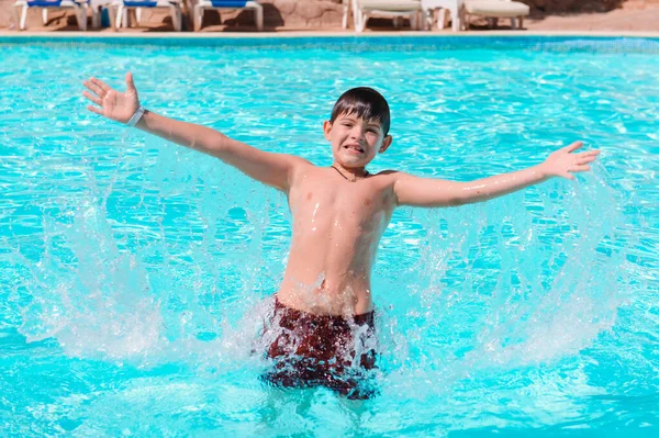 Азарт в бассейне, дети плавают и играют в воду, счастье и лето. Молодой мальчик весело в бассейне с очками. Летние каникулы. — стоковое фото