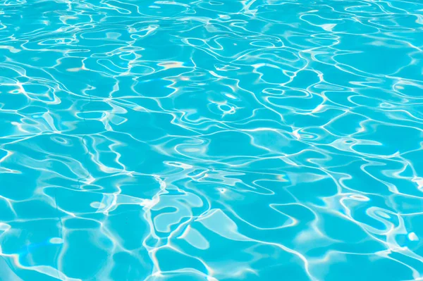 Красивая чистая вода в бассейне, отражающаяся на солнце. Прекрасный освежающий голубой бассейн — стоковое фото