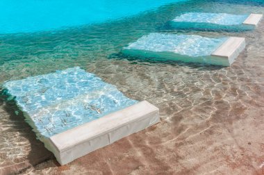 Dinlenmek için su altı yatakları olan yüzme havuzu. Su altı havuzu yatağı