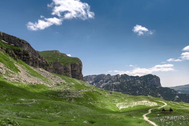 Durmitor dağları, Ulusal Park, Akdeniz, Karadağ, Balkanlar ve Avrupa 'nın muhteşem manzarası. Sedlo Geçidi 'nden parlak yaz manzarası. Dağlardaki evin yanındaki yol..
