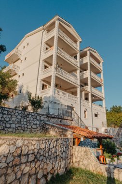 Dekoratif bitkiler ve gün batımında ahşap döşemeleri olan rahat bir villa.