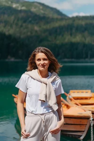Het meisje kijkt naar het Zwarte Meer met vissersboten, bos en bergen in het Durmitor National Park van Montenegro. Een toerist geniet van een magisch uitzicht op het meer, een naaldbos en een magisch — Stockfoto