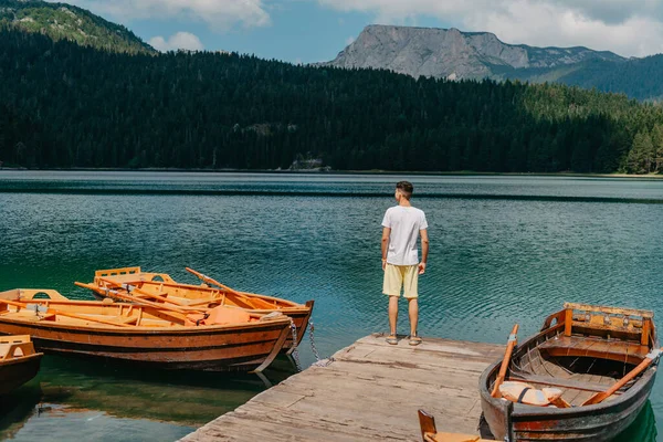 Joven mirando a Lago Negro, Parque Nacional Durmitor, Zabljak, Montenegro. Hipster viajero disfrutando de la vista de Lago Negro — Foto de Stock