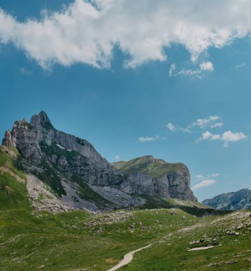 Durmitor dağları, Ulusal Park, Akdeniz, Karadağ, Balkanlar ve Avrupa 'nın muhteşem manzarası. Sedlo Geçidi 'nden parlak yaz manzarası. Dağlardaki evin yanındaki yol..