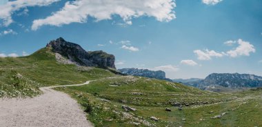 Durmitor dağları, Ulusal Park, Akdeniz, Karadağ, Balkanlar ve Avrupa 'nın muhteşem manzarası. Sedlo Geçidi 'nden parlak yaz manzarası. Dağlardaki evin yanındaki yol..