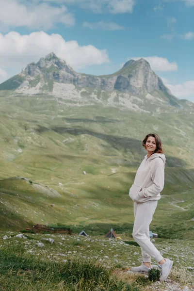 산위에서 서 계곡 경치를 즐기고 있는 관광객 소녀. 두 팔을 벌린 행복 한 여인, 자유와 행복, 산에서의 성취 — 스톡 사진