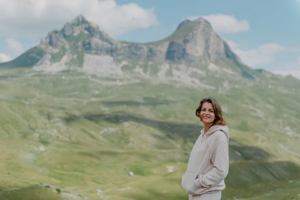 산위에서 서 계곡 경치를 즐기고 있는 관광객 소녀. 두 팔을 벌린 행복 한 여인, 자유와 행복, 산에서의 성취 — 스톡 사진