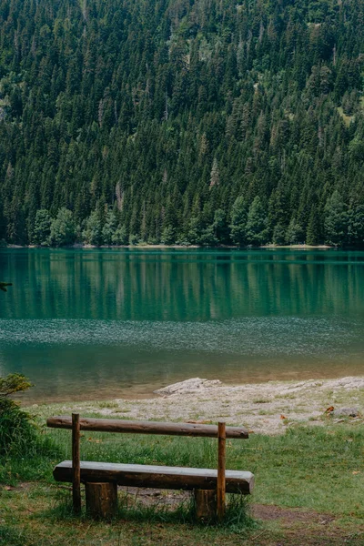 Relaxa. Descanse perto do lago. Banco de madeira com vista para o lago e montanhas. Lindo lago místico. Lago Negro, Parque Nacional Durmitor. Montenegro — Fotografia de Stock