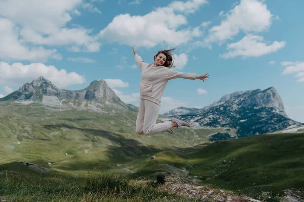 산높은 곳에서 점프하는 아름다운 소녀 행복해. 젊은 여자들은 기쁨에 넘쳐 산속을 뛰고 있다 — 스톡 사진