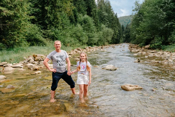 Crianças com pai caminhando nas montanhas dos Alpes atravessando o rio. As crianças brincam na água na montanha. Férias com a família. Uma menina com o pai no trilho da caminhada. Diversão ao ar livre. Recreação ativa com crianças — Fotografia de Stock