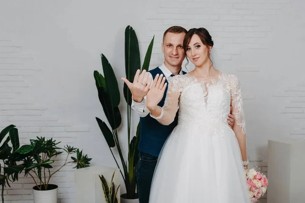 Tournage studio de mariage avec bisous décor, câlins. Joyeux couple. Amoureux mariés dans la décoration de luxe. Mariée et marié ensemble. Deux câlins. Jeunes mariés le jour du mariage. Élégant marié et mariée — Photo