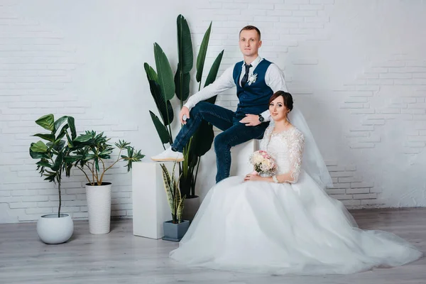 Tournage studio de mariage avec bisous décor, câlins. Joyeux couple. Amoureux mariés dans la décoration de luxe. Mariée et marié ensemble. Deux câlins. Jeunes mariés le jour du mariage. Élégant marié et mariée — Photo