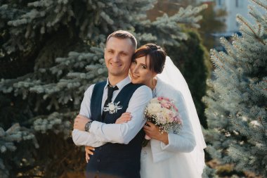 Zarif gelin ve damat bir düğün gününde birlikte açık havada poz. Damat ve Gelin parkta. Gelinlik. Çiçek Gelin düğün buketi