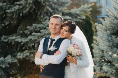 Zarif gelin ve damat bir düğün gününde birlikte açık havada poz. Damat ve Gelin parkta. Gelinlik. Çiçek Gelin düğün buketi