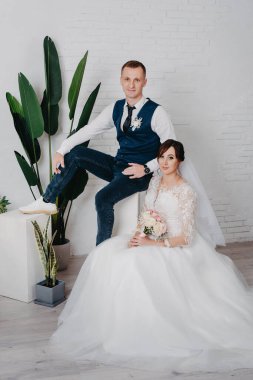 Düğün stüdyosu çekimleri, dekor öpücükler, sarılmalar. Mutlu bir çift. Lüks dekorasyonlu gelin ve damat aşıkları. Gelin ve damat birlikte. Çift kucaklaşması. Yeni evliler düğün gününde. Zarif gelin ve damat