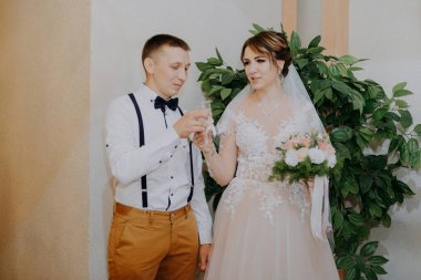 Gelin ve damat düğünde şampanya içiyorlar. Kafkasyalı orta yaşlı gelin ve damat şampanya içip gülümsüyor.