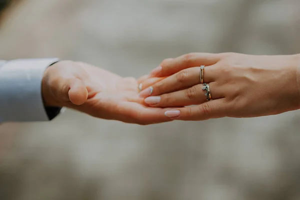 Свадебная пара держится за руки на закате. Обручальные кольца. Мужчина дарит обручальное кольцо своей девушке . — стоковое фото