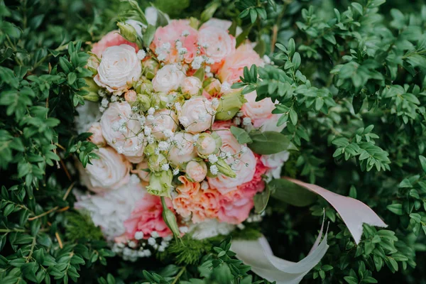 Mira desde arriba en blanco nd ramo de flores de la boda de color rosa acostado en el arbusto. Un hermoso ramo nupcial de rosas blancas se encuentra en un arbusto verde. Enfoque suave. —  Fotos de Stock