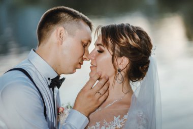 Genç bir çiftin şehvetli portresi. Düğün fotoğrafı dışarıda. Gelin ve damadın parkta düğün fotoğrafı. Yeni evli çift kucaklaştı..