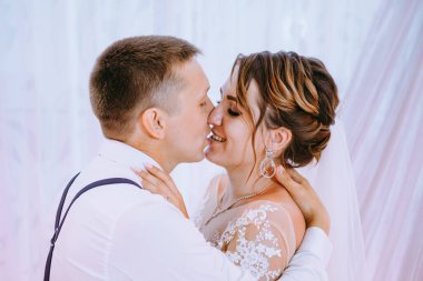 Düğün ziyafetinde romantik öpüşme gelin ve damat. Düğün ziyafeti. Gelin ve damat masada. Herkes eğleniyor. Gülümse ve öp. Düğün ziyafeti. gelin ve damat bir restoranda.