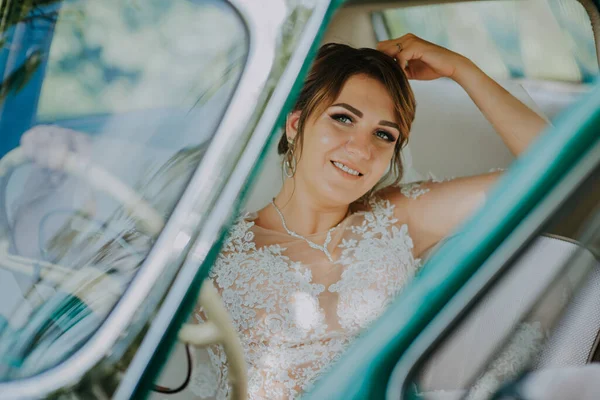 Boda novia descanso y divertirse en verde vintage coche retro después de la boda. Concepto de luna de miel. Mujer del coche feliz en viejo coche retro vintage. Mujer joven conduciendo en viaje por carretera en hermoso día soleado de verano. —  Fotos de Stock