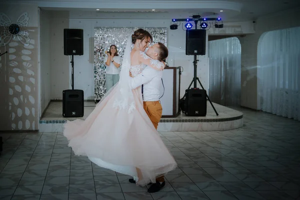 아름다운 코카서스 부부는 얼마 전에 결혼하여 첫 춤을 추었습니다. 부부가 알아볼 수없는 친구들 앞에서 춤을 추고 있는 모습. — 스톡 사진