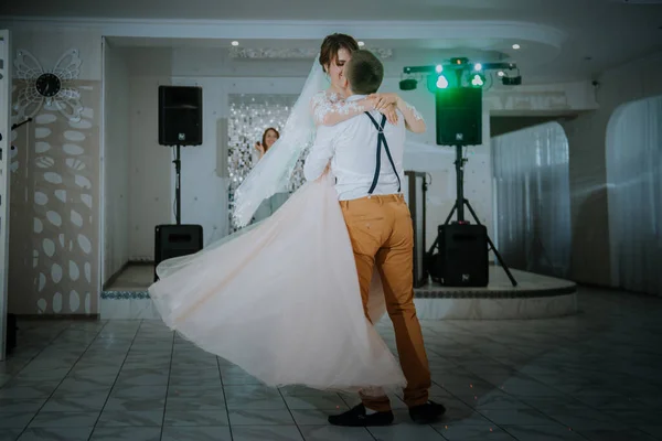 Hermosa pareja caucásica acaba de casarse y bailar su primer baile. Pareja casada bailando delante de sus amigos irreconocibles. —  Fotos de Stock