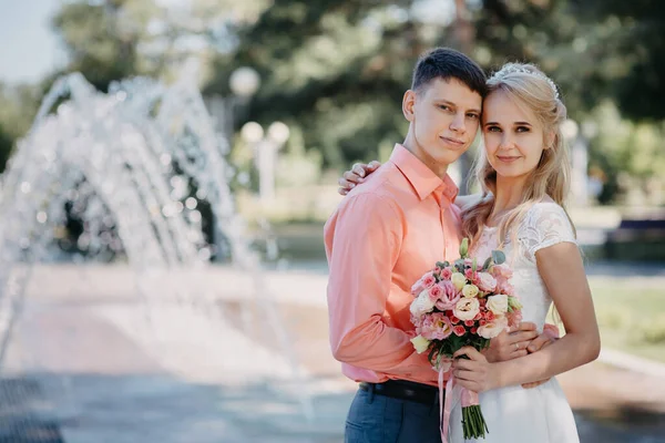 Щасливий наречений і наречений на весільній прогулянці біля фонтану. Наречена і наречена мають романтичний момент у день весілля . — стокове фото