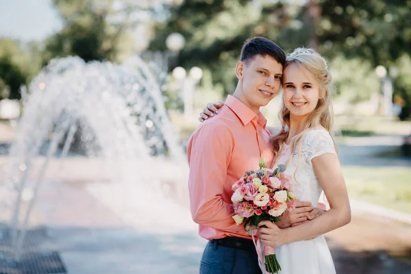 Happy bride and groom on wedding walk near fountain. Bride and groom having a romantic moment on their wedding day. — Fotografia de Stock