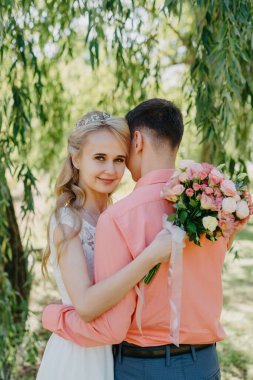 Gelin ve damat gün açık havada yürüyüş düğününde doğa bahar. Gelin Çift, mutlu yeni evli kadın ve yeşil park kucaklayan adam. Sevgi dolu evlilik çift açık. Gelin ve damat, düğün çekim