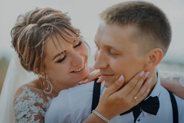 Hot woman showing tenderness man in garden. Portrait of sexy couple expressing feelings in park. Close up gorgeous bride and groom kissing on wedding ceremony outdoors. Bride and groom kisses tenderly — Stock Photo, Image