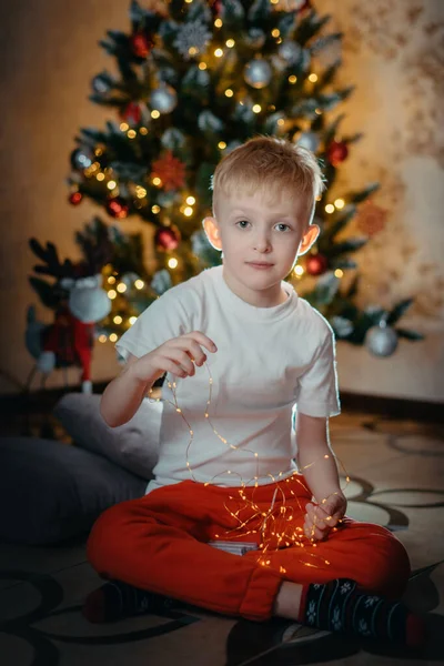 Adorable little baby boy sitting in front of a christmas tree. Christmas Child Open Present Gift, Happy Baby Boy looking to Magic Light in Box, Kid sitting front of Xmas Tree — Stock Photo, Image