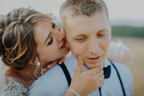 Hot woman showing tenderness man in garden. Portrait of sexy couple expressing feelings in park. Close up gorgeous bride and groom kissing on wedding ceremony outdoors. Bride and groom kisses tenderly — Fotografia de Stock