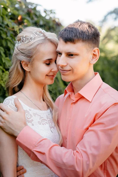 Gelin ve damat gün açık havada yürüyüş düğününde doğa bahar. Gelin Çift, mutlu yeni evli kadın ve yeşil park kucaklayan adam. Sevgi dolu evlilik çift açık. Gelin ve damat, düğün çekim