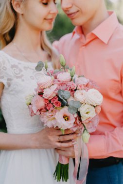 Gelin ve damat gün açık havada yürüyüş düğününde doğa bahar. Gelin Çift, mutlu yeni evli kadın ve yeşil park kucaklayan adam. Sevgi dolu evlilik çift açık. Gelin ve damat, düğün çekim