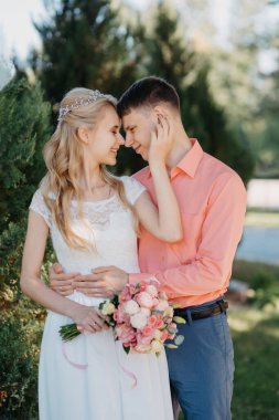 Gelin ve damat gün açık havada yürüyüş düğününde doğa bahar. Gelin Çift, mutlu yeni evli kadın ve yeşil park kucaklayan adam. Sevgi dolu evlilik çift açık. Gelin ve damat, düğün çekim