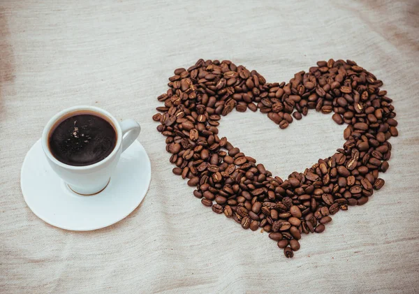 Secangkir Coffe. Biji kopi dalam bentuk hati. Biji kopi diisolasi pada latar belakang putih. biji kopi panggang, dapat digunakan sebagai latar belakang . — Stok Foto
