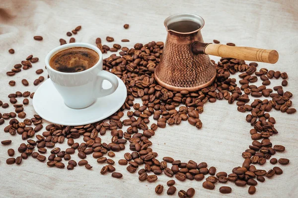 Kaffee Türke und Tasse Kaffee. Kaffeebohnen in Herzform. Kaffeebohnen isoliert auf weißem Hintergrund. geröstete Kaffeebohnen, können als Hintergrund verwendet werden. — Stockfoto
